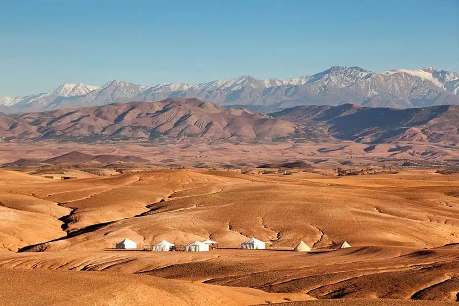 Agafay Desert camp with the snow capped High Atlas Mountains in the backdrop