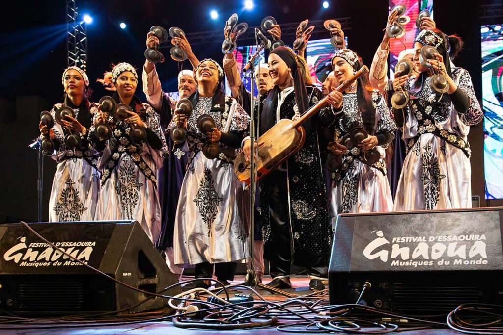 Gnaoua musicians on stage in Essaouira, beating krakebs and guembri at world-famous festival