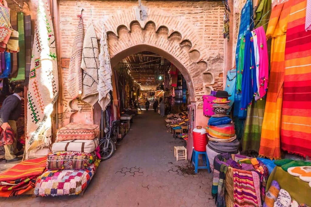 Carpet-lined archway leading into Marrakech’s bustling souks