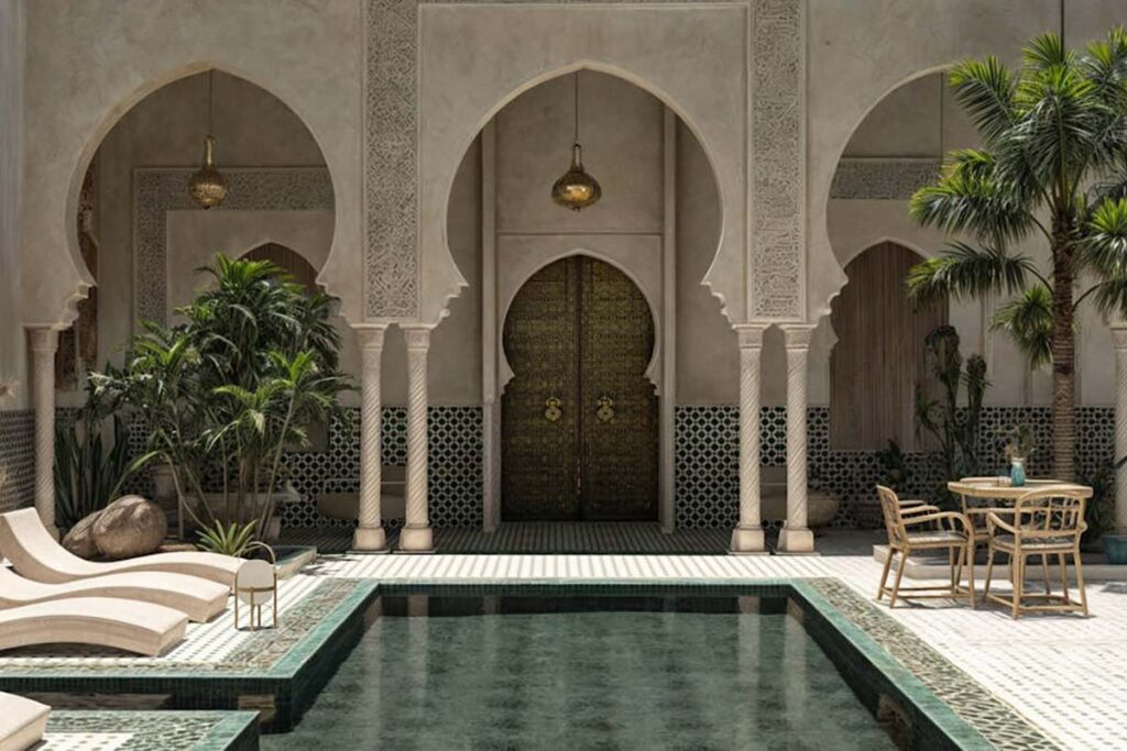 Elegant riad courtyard with pool, arches and carved cedar door in Marrakech