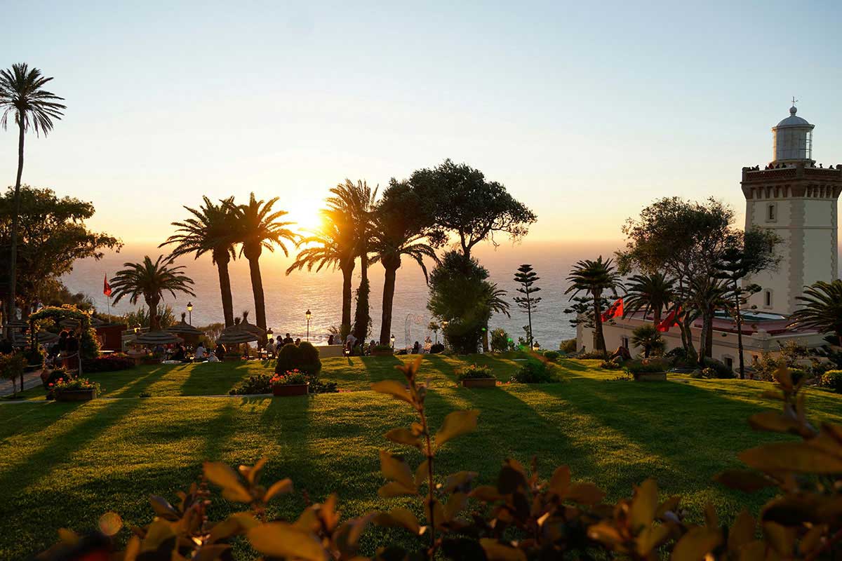Cap Spartel lighthouse and palm‑lined gardens overlooking the Atlantic at sunset, Tangier, Northern Morocco