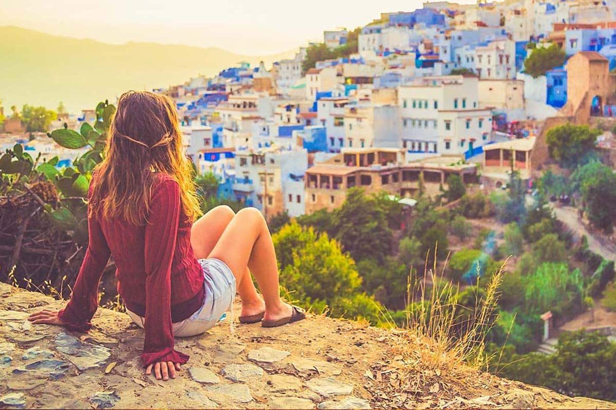 Woman overlooking the blue city of Chefchaouen at sunset